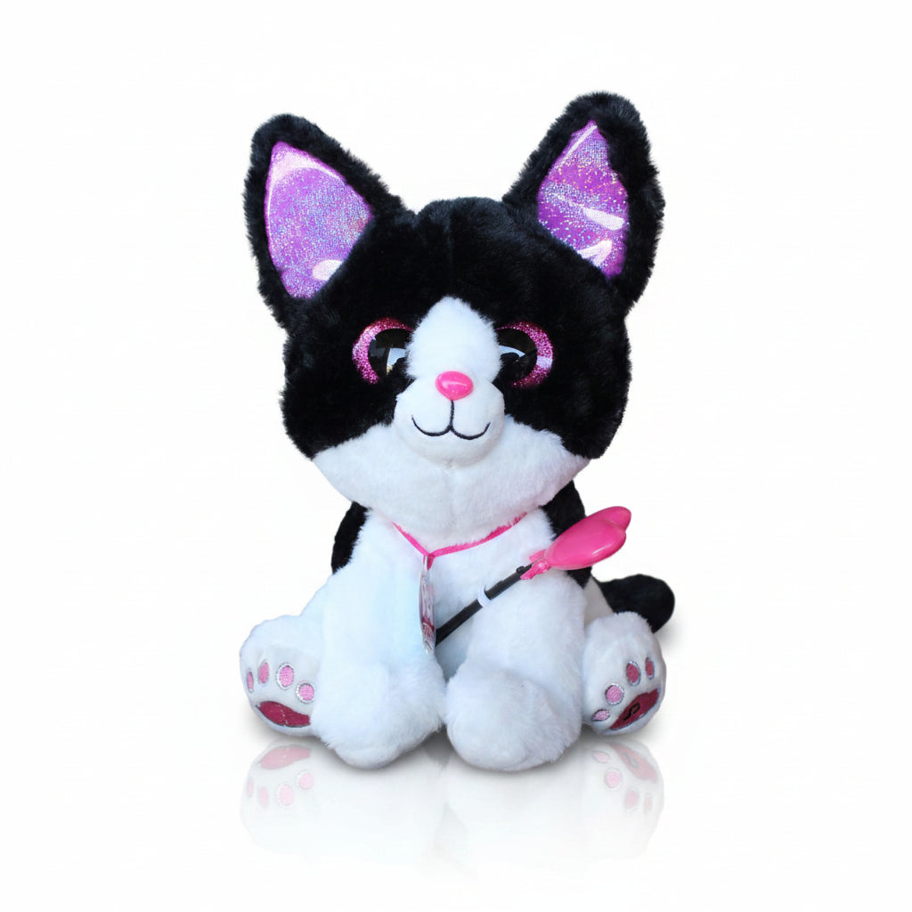 Crno-bela plišana interaktivna maca Magic Kitty sa ljubičastim svetlucavim ušima, roze nosićem i čarobnim štapićem pored originalne roze kutije.