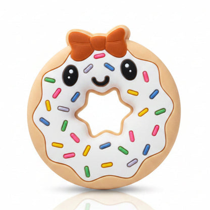 Mekana silikonska glodalica bež boje u obliku krofne sa crvenom mašnicom, nasmejanim očima i šarenim mrvicama u blister pakovanju Baby teether.