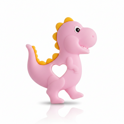 Dečija roze glodalica dinosaurus od bezbednog silikona u providnom blister pakovanju sa oznakom soft comfort.